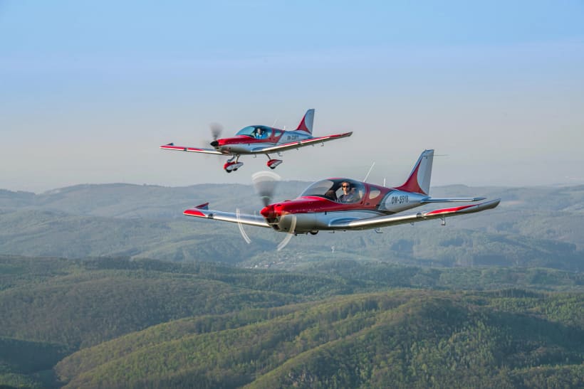 Two Bristell UL/LSA aircraft flying in formation over the countryside