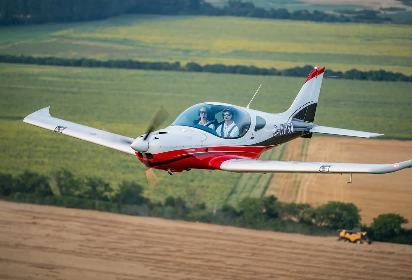 A Bristell light aircraft in flight with its retractable landing gear retracted