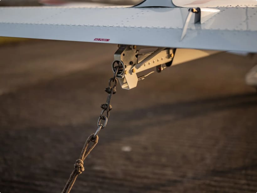 Glider tow-release hook mounted under the rear fuselage of a Bristell with a tow rope attached.